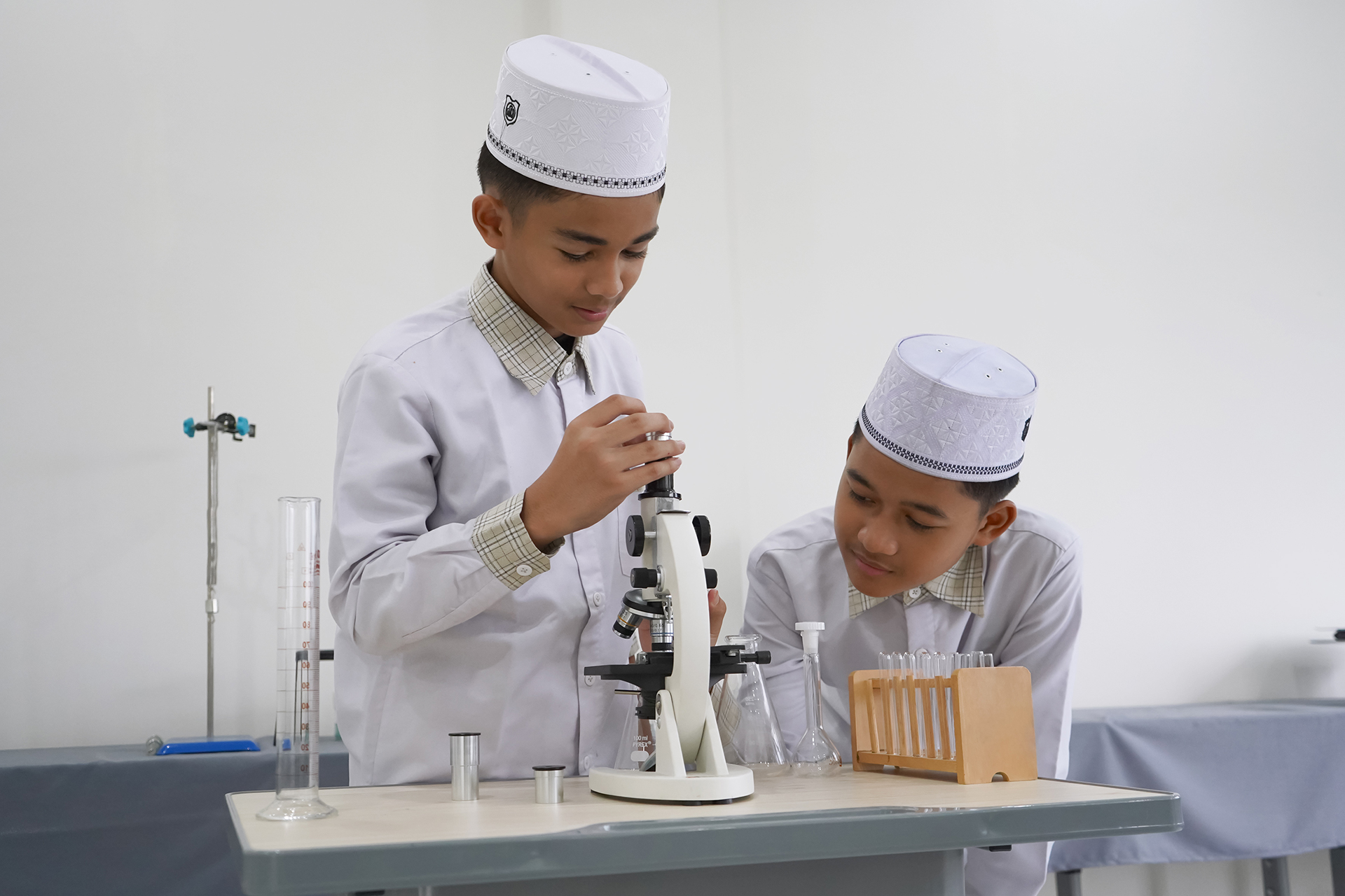 Dua santri mengamati sampel dengan mikroskop di laboratorium